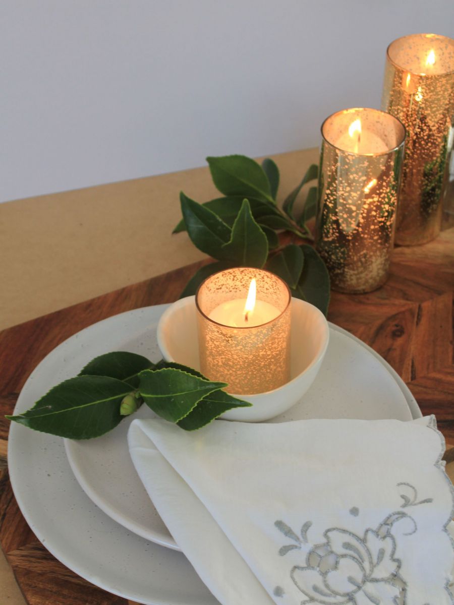 Image of gold candle holders with place setting and vintage napkin on wedding table